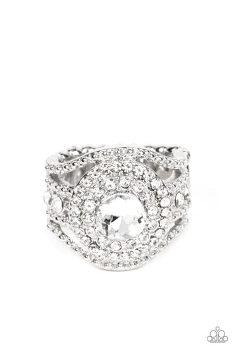 Bordered in stacked rings of glassy white rhinestones, a brilliant white gem sits atop layers of silver studded bars that swoop and stack into blinding bands across the finger. Features a stretchy band for a flexible fit.