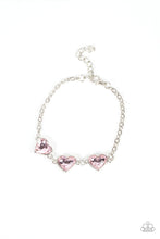 Load image into Gallery viewer, Nestled in silver frames, a trio of glittery pink heart-shaped gems delicately links across the wrist for a dash of swoon-worthy shimmer. Features an adjustable clasp closure. 
