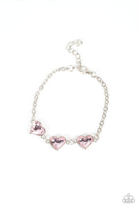 Nestled in silver frames, a trio of glittery pink heart-shaped gems delicately links across the wrist for a dash of swoon-worthy shimmer. Features an adjustable clasp closure. 