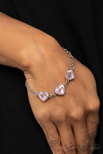 Load image into Gallery viewer, Nestled in silver frames, a trio of glittery pink heart-shaped gems delicately links across the wrist for a dash of swoon-worthy shimmer. Features an adjustable clasp closure. 
