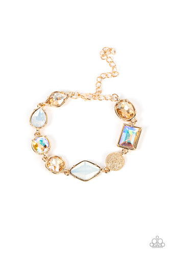 Encased in pronged gold fittings, a mismatched collection of golden, iridescent, and opal rhinestones delicately links with a studded gold frame around the wrist for a sentimental sparkle. Features an adjustable clasp closure. </P><br>Featured inside The Preview at GLOW! 