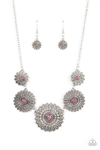 Infused with a whimsical mandala-like motif, tactile silver petals bloom from pink rhinestone dotted centers below the collar. The mismatched silver flowers gradually increase in size, exaggerating the eye-catching details. Features an adjustable clasp closure. 
