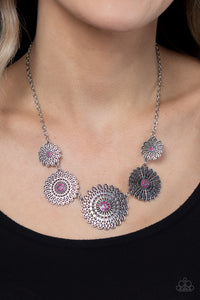 Infused with a whimsical mandala-like motif, tactile silver petals bloom from pink rhinestone dotted centers below the collar. The mismatched silver flowers gradually increase in size, exaggerating the eye-catching details. Features an adjustable clasp closure. 