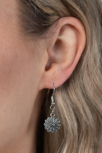 Infused with a whimsical mandala-like motif, tactile silver petals bloom from pink rhinestone dotted centers below the collar. The mismatched silver flowers gradually increase in size, exaggerating the eye-catching details. Features an adjustable clasp closure. 