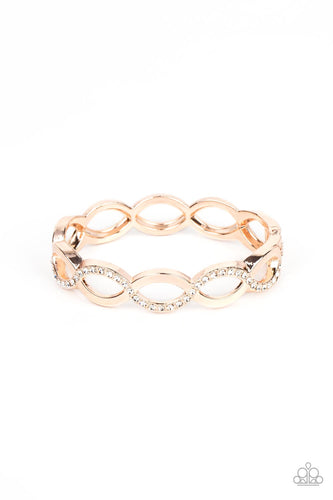 Rose gold bars elegantly intertwine into infinity inspired frames that delicately hinge around the wrist. The front of the flawless centerpiece is dusted in a wavy row of white rhinestones, adding a timeless twinkle to the versatile design. Features a hinged closure. 
