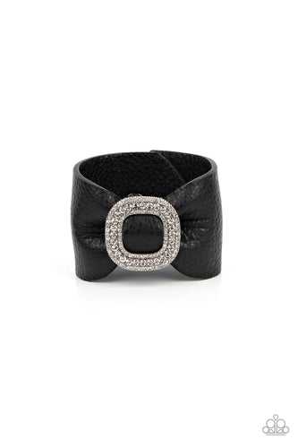 A thick black pleather band delicately knots around the wrist. Stacked with brilliant white rhinestones, a dramatic silver buckle sparkles at the center of the wrist for a dramatic finish. Features an adjustable snap closure.