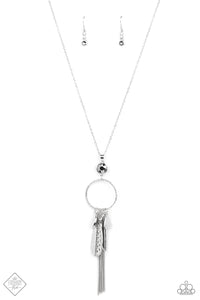 Featuring both smooth and hammered finishes, dainty smoky rhinestones, and a tassel of dainty chains, a sassy collection of silver charms swings from the bottom of a brightly textured circle. A faceted hematite gem sits atop the harmoniously audacious display at the bottom of a lengthened dainty silver chain for a crowning finish. Features an adjustable clasp closure.  Sold as one individual necklace. Includes one pair of matching earrings.  New Kit Fashion Fix