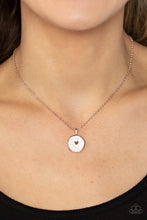 Load image into Gallery viewer, Painted in a shimmery white lacquer finish, an asymmetrical rose gold disc is dotted in a dainty rose gold heart accent as it swings from the bottom of a dainty rose gold chain below the collar for a charming finish. Features an adjustable clasp closure.
