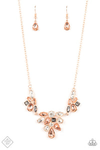 Featuring a ravishing radiance, varying shapes of peach, smoky, and white gems gather into scattered clusters. The resplendent gems, set in pronged rose gold fittings, delicately connect to a dainty rose gold chain, creating a captivating statement piece below the collar. Features an adjustable clasp closure.  Sold as one individual necklace. Includes one pair of matching earrings.  New Kit Fashion Fix