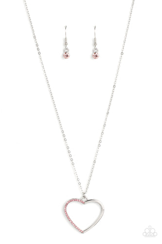 One side of a shiny silver heart frame has been adorned in dainty pink rhinestones, resulting in a flirtatious pendant at the bottom of a dainty silver chain. Features an adjustable clasp closure.