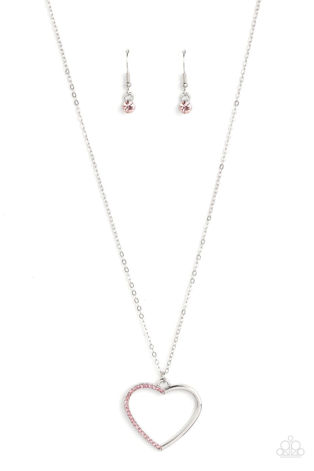 One side of a shiny silver heart frame has been adorned in dainty pink rhinestones, resulting in a flirtatious pendant at the bottom of a dainty silver chain. Features an adjustable clasp closure.