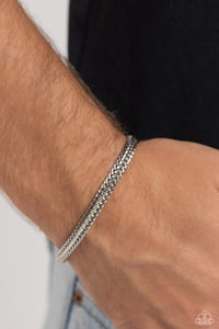 Intricate silver chains interlock into an edgy centerpiece around the wrist, resulting in a gritty statement piece. Features a magnetic closure