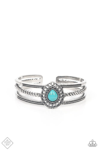 A turquoise teardrop stone, encased in an embellished studded frame, sits prominently at the center of three silver bands. Wrapped in ropelike and studded texture, the rustic bands coalesce into an airy cuff bracelet.  Sold as one individual bracelet.  New Kit Fashion Fix