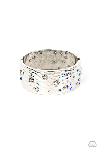 Twinkling with dainty silver stars, hammered silver frames are adorned with a smattering of iridescent blue rhinestones as they delicately join into a bangle-like bracelet around the wrist. Due to its prismatic palette, color may vary. Features a hinged closure. 
