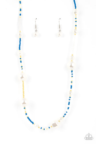 Irregular-shaped pearls in varying sizes are scattered amongst blue, yellow, and white seed beads that are threaded along a wire, resulting in a refreshing and playful style below the collar. 