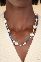 Load image into Gallery viewer, Irregular-shaped pearls in varying sizes are scattered amongst blue, yellow, and white seed beads that are threaded along a wire, resulting in a refreshing and playful style below the collar. 
