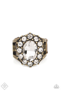 A dauntless oval rhinestone is encircled by dainty sparkling gems. Accented with petite antiqued brass studs, the dramatic design joins with an airy layered brass band to create a captivating arrangement atop the finger. Features a stretchy band for a flexible fit.  Sold as one individual ring.  New Kit Fashion Fix