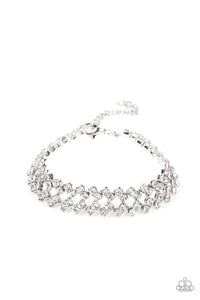 Set in pronged silver settings, pairs of icy white rhinestones haphazardly stack around the wrist in sizzling rows of shimmer. Features an adjustable clasp closure.  Sold as one individual bracelet.