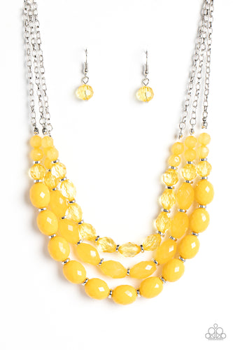 Separated by dainty silver rings, mismatched rows of glassy, opaque, and solid Daffodil acrylic crystal-like beads are threaded along invisible wires below the collar, creating vivacious layers. Features an adjustable clasp closure. Featured inside The Preview at GLOW!