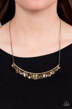 Load image into Gallery viewer, A curved bar of antiqued brass is trimmed with a mashup of glitzy aurum and faceted golden topaz gems that shimmer inside studded brass frames, creating a scintillating sparkle below the collar. Features an adjustable clasp closure. 
