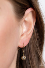 Load image into Gallery viewer, A curved bar of antiqued brass is trimmed with a mashup of glitzy aurum and faceted golden topaz gems that shimmer inside studded brass frames, creating a scintillating sparkle below the collar. Features an adjustable clasp closure. 
