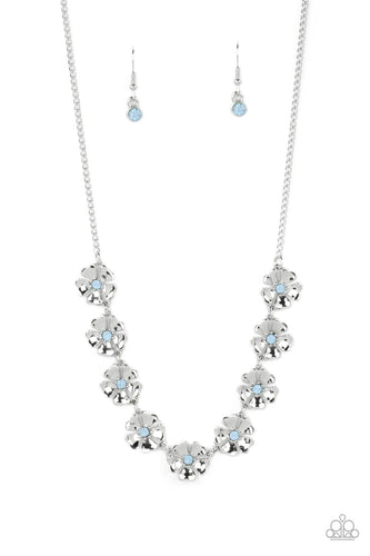 Heart-shaped silver petals bloom from opaque Spun Sugar rhinestone centers, creating colorful flowers. The dainty floral frames delicately dance below the collar, connecting into a whimsical centerpiece. Features an adjustable clasp closure.