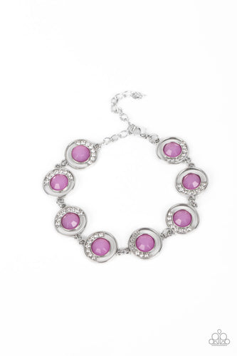 An arc of glassy white rhinestones curls around one side of an opaque purple gem inside a dainty silver hoop. The twinkly frames delicately link around the wrist, creating a mystical centerpiece. Features an adjustable clasp closure. 