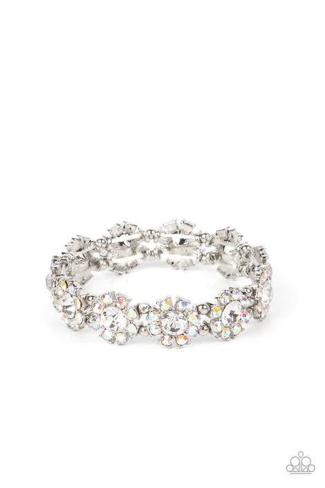 Separated by pairs of dainty silver beads, iridescent rhinestone dotted petals bloom from oversized white rhinestone centers along stretchy bands around the wrist for a flirtatious floral fashion. Due to its prismatic palette, color may vary.  Life Of The Party July 2022