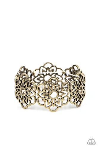 Airy brass petals bloom into mandala-like blossoms along stretchy bands around the wrist, creating a rustic floral pattern. 