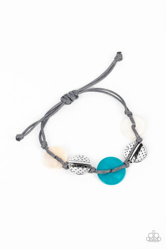 Vibrant blue and white shell discs interlace with silver dotted, hammered discs to create this refined pop of color. Held together by soft gray cording, this piece will blend in with beaches near you! Features an adjustable sliding knot closure. 