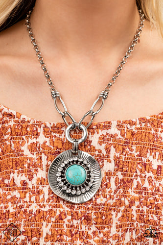 A circle of glassy white rhinestones fans out around an oversized turquoise stone, centered atop a warped silver disc. Etched with linear details, the earthy pendant attaches to oversized silver links, creating an artisan inspired statement piece. Features an adjustable clasp closure.  Sold as one individual necklace. Includes one pair of matching earrings.  New Kit Fashion Fix