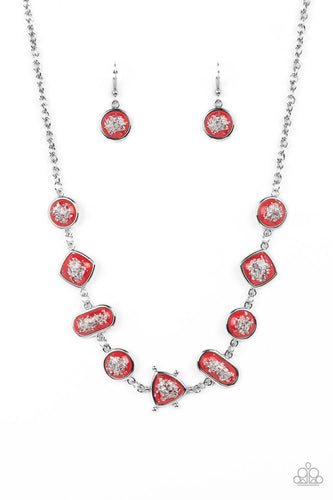 Glassy red beads speckled in flecks of silver shimmer delicately hang from a silver clasped chain, linking into a glitzy geometric pattern along the collar. Features an adjustable clasp closure. 