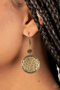 A dainty collection of smooth and hammered brass rings gives way to an antiqued brass disc. Bordered in an asymmetrical brass trim, the hammered disc ripples in the light with each turn and twist. Earring attaches to a standard fishhook fitting.