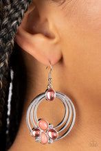 Load image into Gallery viewer, Glassy and opaque coral beads are strategically placed around rings of silver and accented white rhinestones to create a dreamy beach look. Earring attaches to a standard fishhook fitting.
