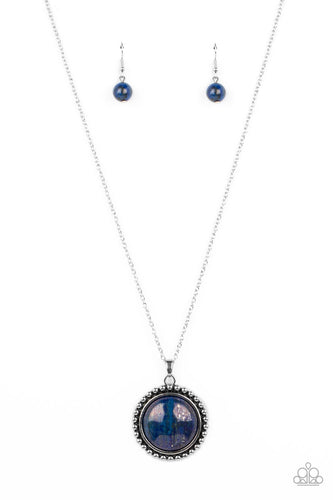 A delicate elongated silver chain leads down to a lapis stone set in the center of a decorative silver-studded frame, creating an exaggerated earthy centerpiece. Features an adjustable clasp closure. As the stone elements in this piece are natural, some color variation is normal