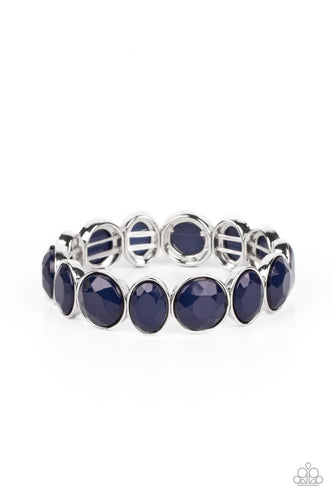 Faceted round and oval blue beads are threaded along a stretchy band around the wrist, resulting in a refreshing pop of color. 