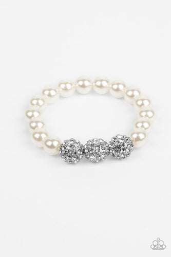 A trio of silver beads encrusted in rhinestones is centered along a strand of classic white pearls. The beads are threaded along a stretchy band, wrapping around the wrist in a refined finish.