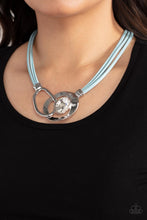Load image into Gallery viewer, Attached to shimmery strands of blue leather, a pair of oversized and warped silver links delicately overlaps into a contemporary centerpiece below the collar. An exaggerated white gem asymmetrically embellishes the silvery accent piece, adding unexpected elegance to the modern design. Features an adjustable clasp closure. 
