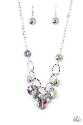 A collection of round, glassy purple-shaded beads in varying sizes swirl around shiny silver oval links hammered in texture. The beveled shape and faceted surfaces of the beads are brushed in a subtle oil-spill glaze, creating a dreamy display as they drip below the collar. Features an adjustable clasp closure. Due to its prismatic palette, color may vary. 