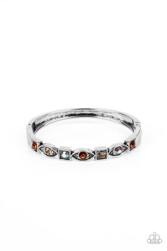 A collection of square and marquise-shaped frames arc across the wrist in a stunning geometric display. Tea, light topaz, and iridescent rhinestones are pressed into the centers of the thick silver frames, adding irresistible sparkle to the bangle-inspired design. Features a hinged closure. Due to its prismatic palette, color may vary. 