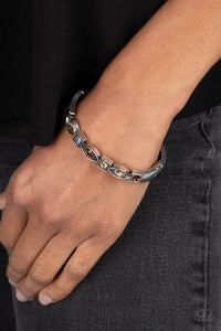 A collection of square and marquise-shaped frames arc across the wrist in a stunning geometric display. Tea, light topaz, and iridescent rhinestones are pressed into the centers of the thick silver frames, adding irresistible sparkle to the bangle-inspired design. Features a hinged closure. Due to its prismatic palette, color may vary. 