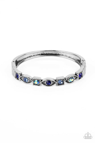 A collection of square and marquise-shaped frames arc across the wrist in a stunning geometric display. Sapphire, light sapphire, and blue iridescent rhinestones are pressed into the centers of the thick silver frames, adding irresistible sparkle to the bangle-inspired design. Features a hinged closure. Due to its prismatic palette, color may vary.