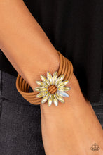 Load image into Gallery viewer, Row after row of brown suede cords layer around the wrist. Featuring oblong marquise style cuts, a collection of yellow and iridescent rhinestones fans out into a circular focal point, resulting in a celestial centerpiece. Features a magnetic closure. Due to its prismatic palette, color may vary. 
