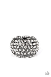 A thick band of gunmetal arcs across the top of the finger, creating an exaggerated rounded frame. Countless tiny white rhinestones scatter across the surface, as straight lines of even more rhinestones line the outer edges in a blinding finish. Features a stretchy band for a flexible fit. 