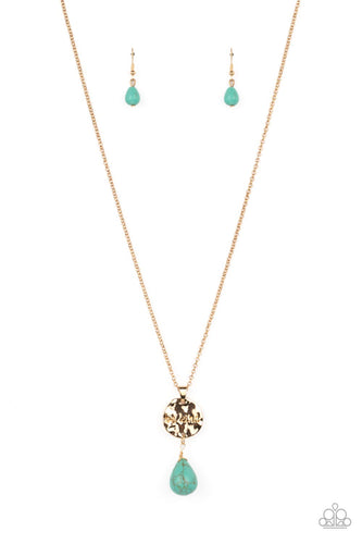 Swinging from a dainty gold chain, a hammered disc in the same hue is stamped with the words 