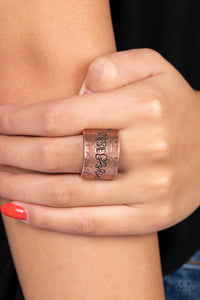 Across a wide copper band with a hammered sheen, the phrase "Rise & Shine" is stamped in varying fonts for a merry message. Features a stretchy band for a flexible fit.
