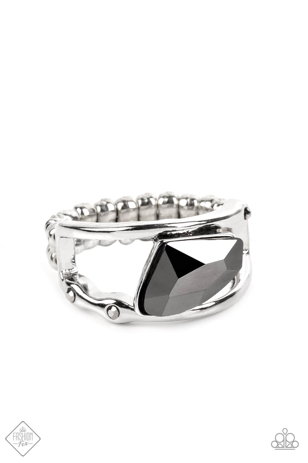 An asymmetrical, jagged piece of hematite emerges from between two bands of silver, creating a smoldering statement piece atop the finger. Tiny flecks of hematite are embedded in the silver bands, adding a hint of additional sparkle to the piece. Features a dainty stretchy band for a flexible fit.  Sold as one individual ring.