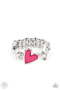 A small pink heart is wrapped in a thick silver frame and nestled between a tiny lightning bolt and star on a skinny silver band that arcs across the finger. Features a dainty stretchy band for a flexible fit.  Sold as one individual ring.