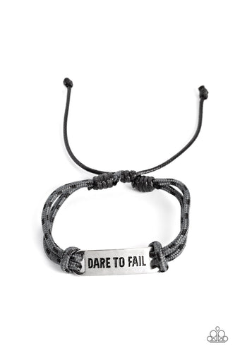 Gray paracord rope, sporadically dotted with black spots, encircles a square silver pendant. Featured on the pendant, the phrase 