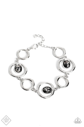 Warped silver hoops curl around black stones that are marbled with white, interlocking into an earthy statement piece around the wrist. Features an adjustable clasp closure. As the stone elements in this piece are natural, some color variation is normal.  Sold as one individual bracelet.